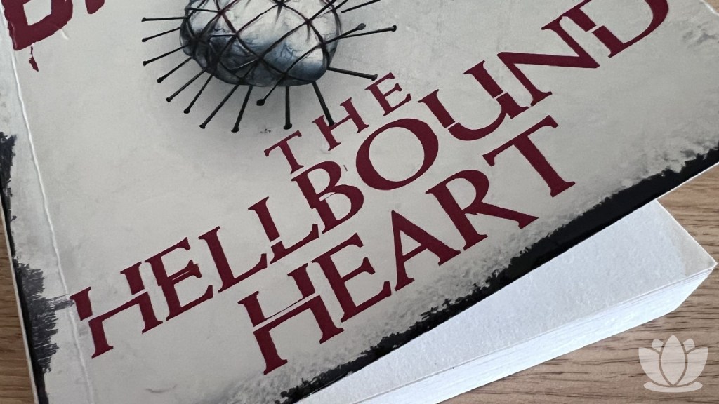 The front cover of The Hellbound Heart by Clive Barker on a wooden desk.