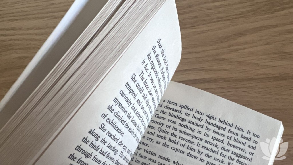 Pages of The Hellbound Heart by Clive Barker on a wooden desk.