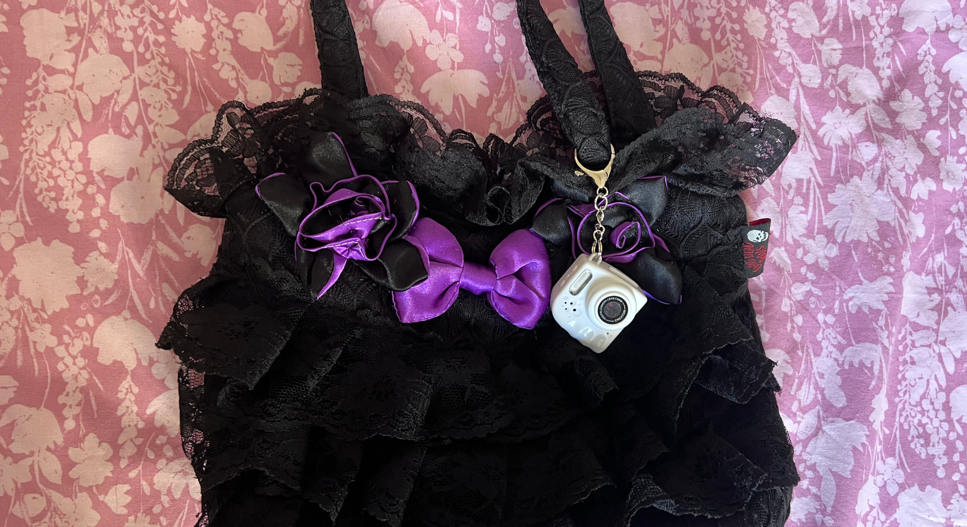 Photo Creator Mini Cam Digital Camera from Canal Toys attached to a frilly black bag.