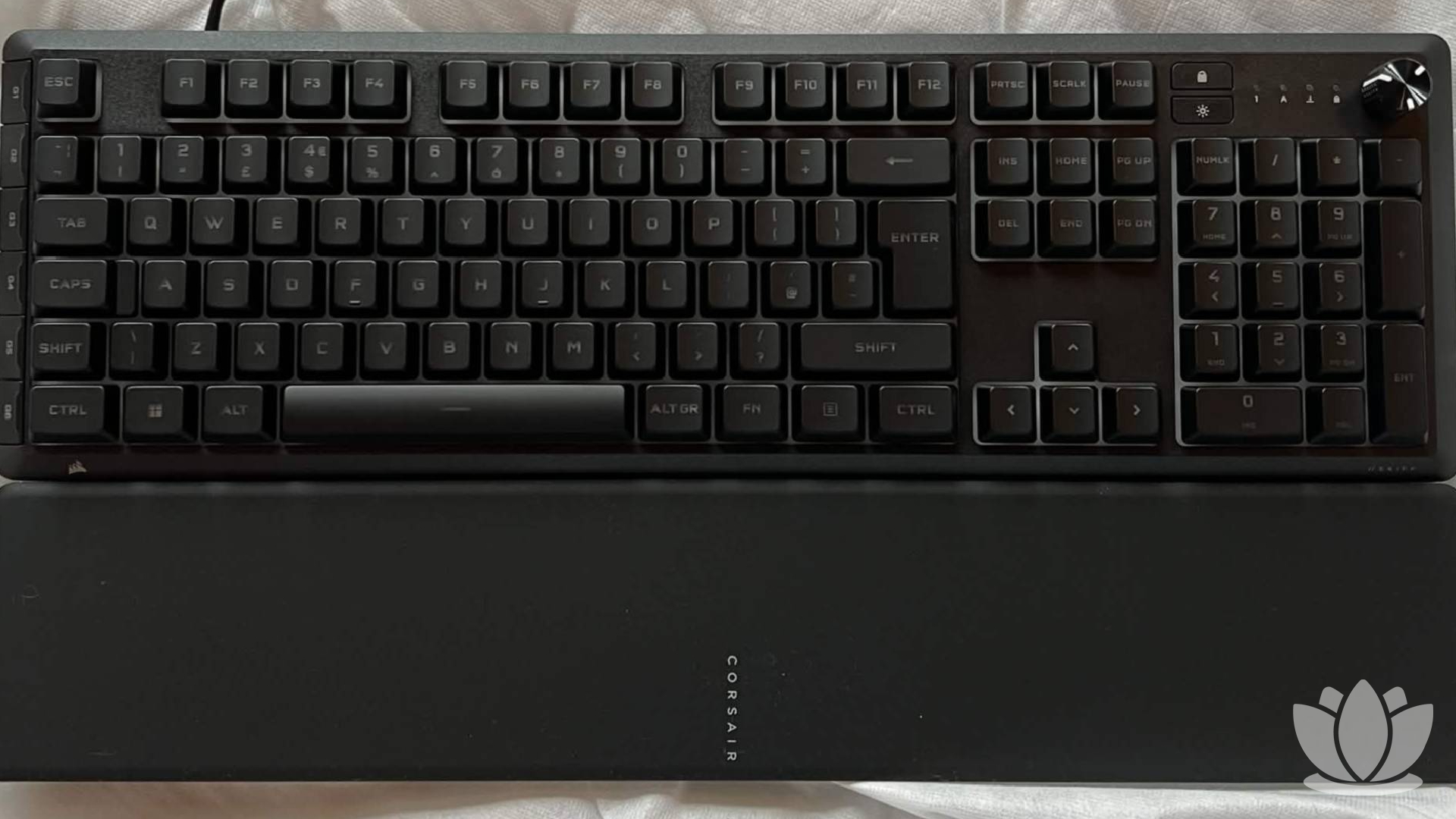 Corsair keyboard shown on a white bed sheet.